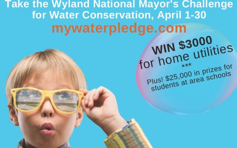 A child with yellow glasses reflecting a river scene, looking at the text 'Take the Wyland National Mayor's Challenge for Water Conservation, April 1-30 mywaterpledge.com WIN $3,000 for home utilities. Plus! $25,000 in prizes for students at area schools